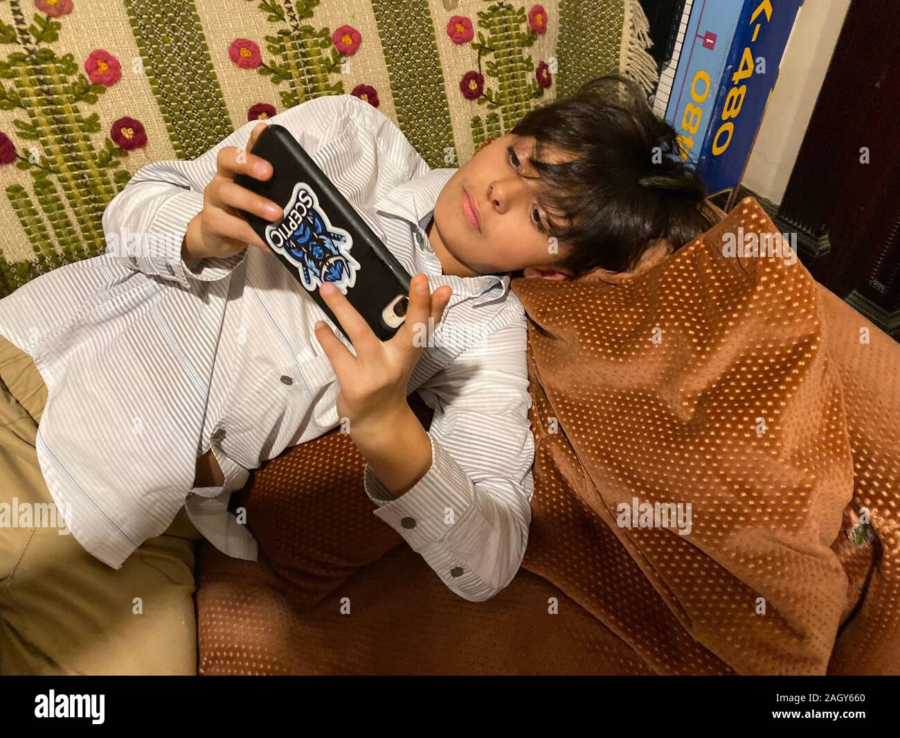 Jungen zu einem Videospiel auf der Couch zu Hause ruhenden geklebt. Stockfoto