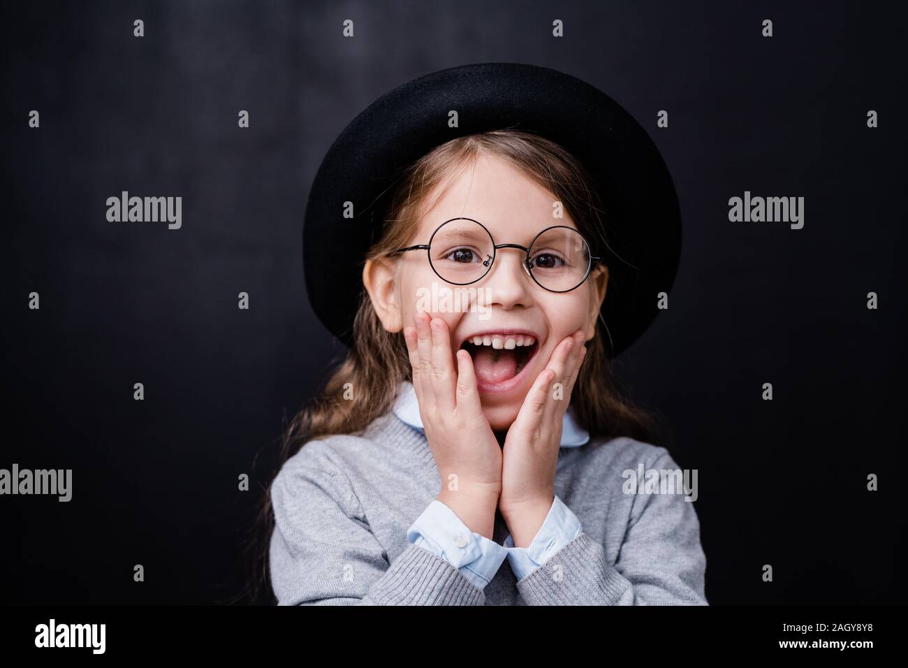 Süße kleine Mädchen in Smart Casual Wear und Brillen Erstaunen zum Ausdruck Stockfoto