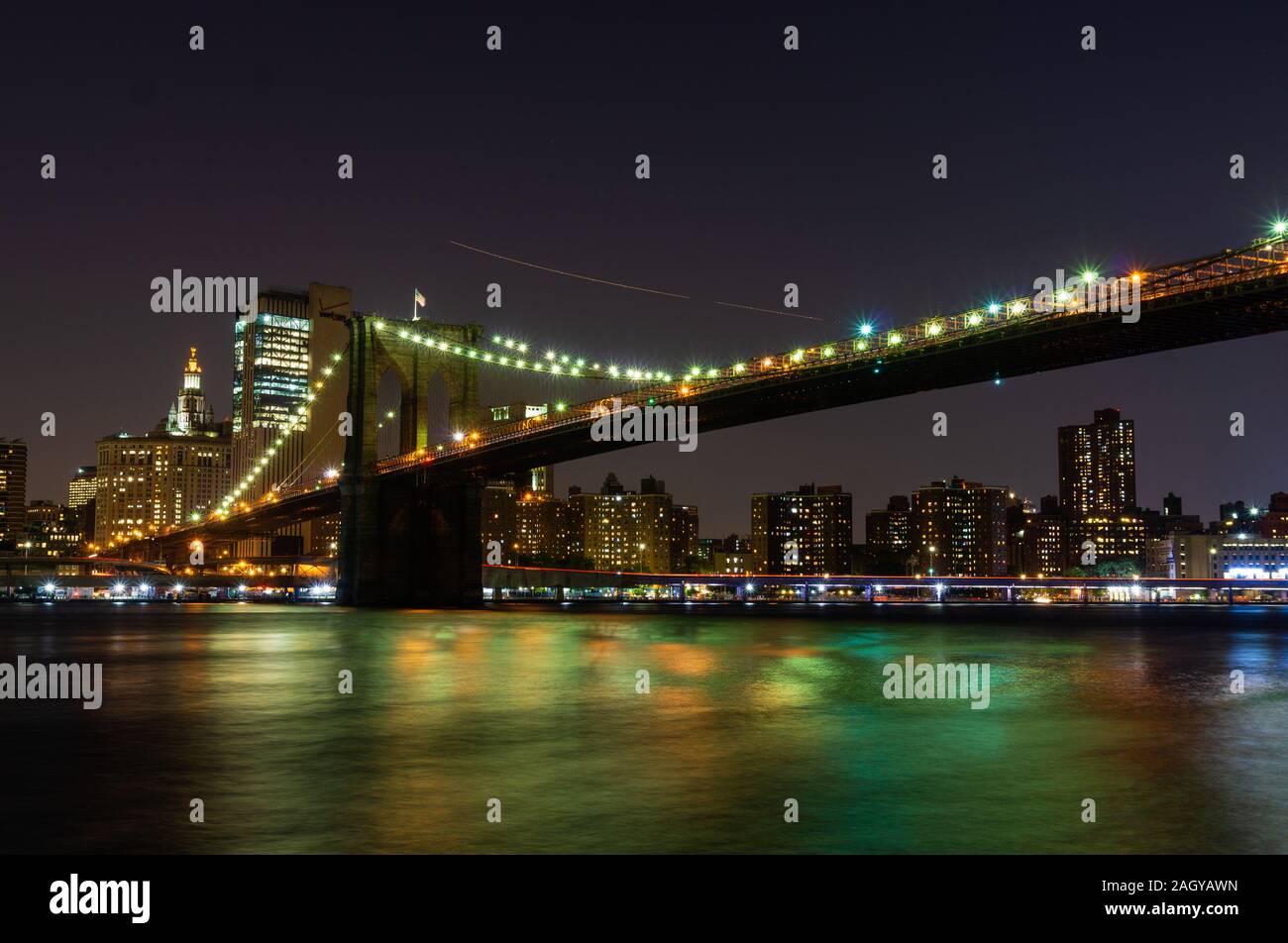 Langzeitbelichtung von New York City Brooklyn Bridge bei Nacht aus Brooklyn Bridge Park gesehen Stockfoto
