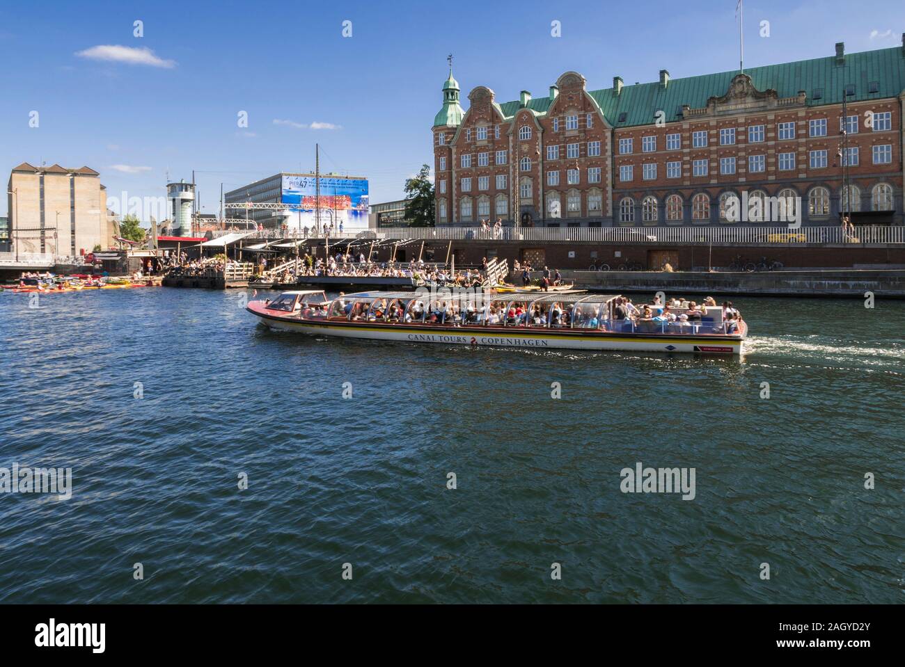 Touristen in einem kleinen Boot vorbei an einem Restaurant im Hafen in Kopenhagen, Dänemark. Stockfoto