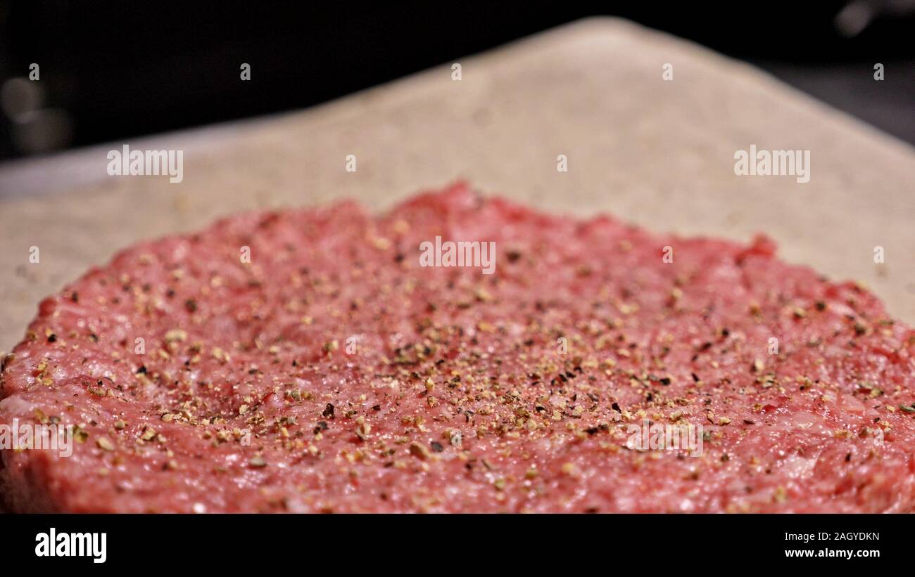 Kochen macht Fleisch Medaillons für Burger. Koch in schwarz Handschuhe macht Schnitzel essen. Die koteletts sind in Stahl Ring in eine noch Medaillon eingeebnet. Stockfoto