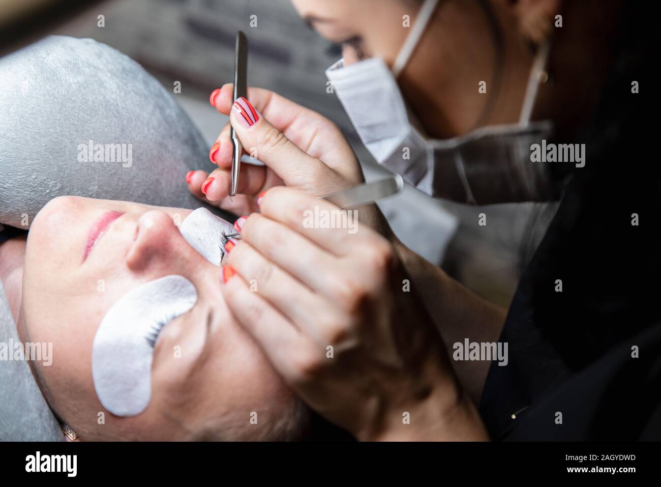 Wimpern stapeln. Prozess der eyelash Extensions im Beauty Studio. Thema der Schönheit und Pflege für sich selbst Stockfoto