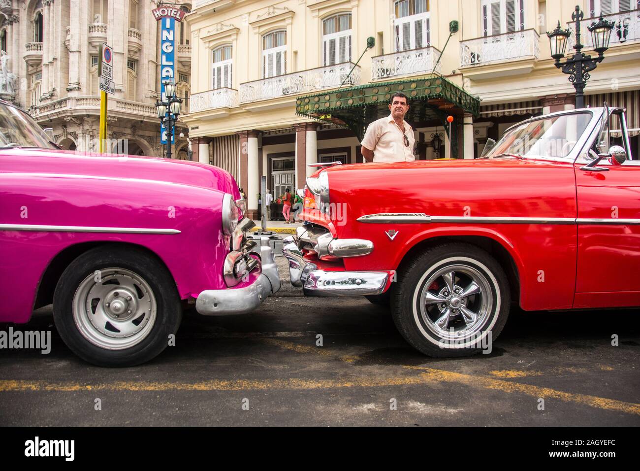 Ein paar klassische Automobile, pink und rot sind, in der Altstadt von der Stadt Havanna, Kuba geparkt Stockfoto