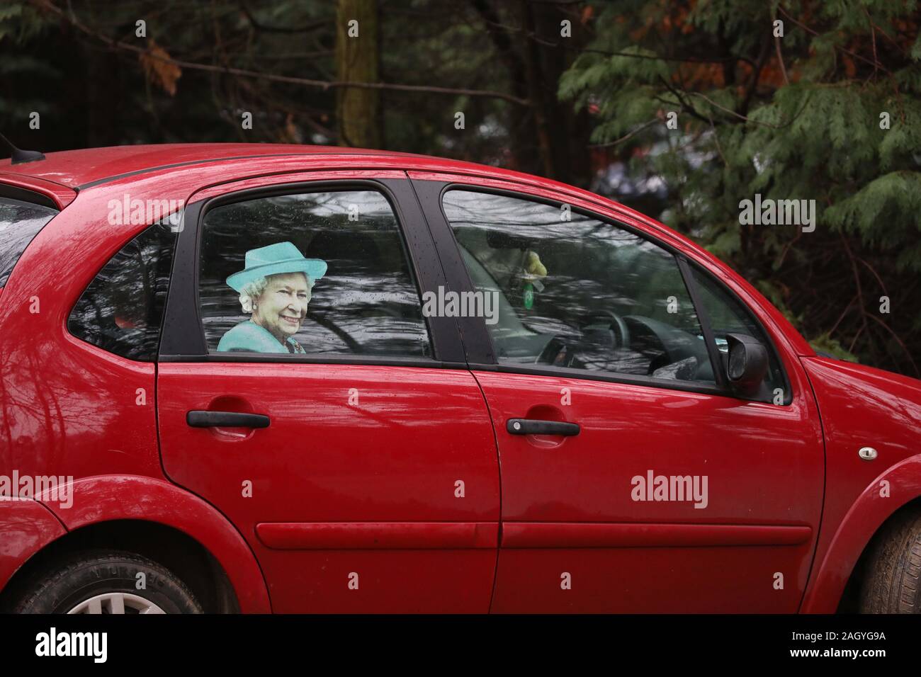 Eine Person mit einem Bild von Königin Elizabeth II. in der Rückseite Ihres Autos, vor Königin Elizabeth II. der St. Maria Magdalena Kirche Sonntag Morgen Service in Sandringham besucht. Derzeit, Prinz Philip (Herzog von Edinburgh), ist im Krankenhaus in London, aber hofft, Sandringham für Weihnachten mit der Königlichen Familie zurückzukehren. Königin Elizabeth II. besucht Kirche, Sandringham, Norfolk, am 22. Dezember 2019. Stockfoto