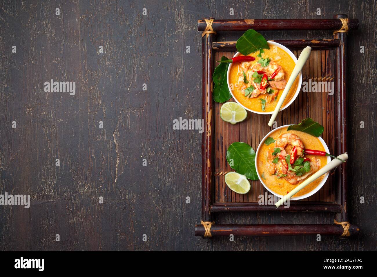 Garnelen Tom Yam Kung in grauen Schale mit thailändischen Gewürzen auf authentisch Fach oben, Holz- Hintergrund. Stockfoto