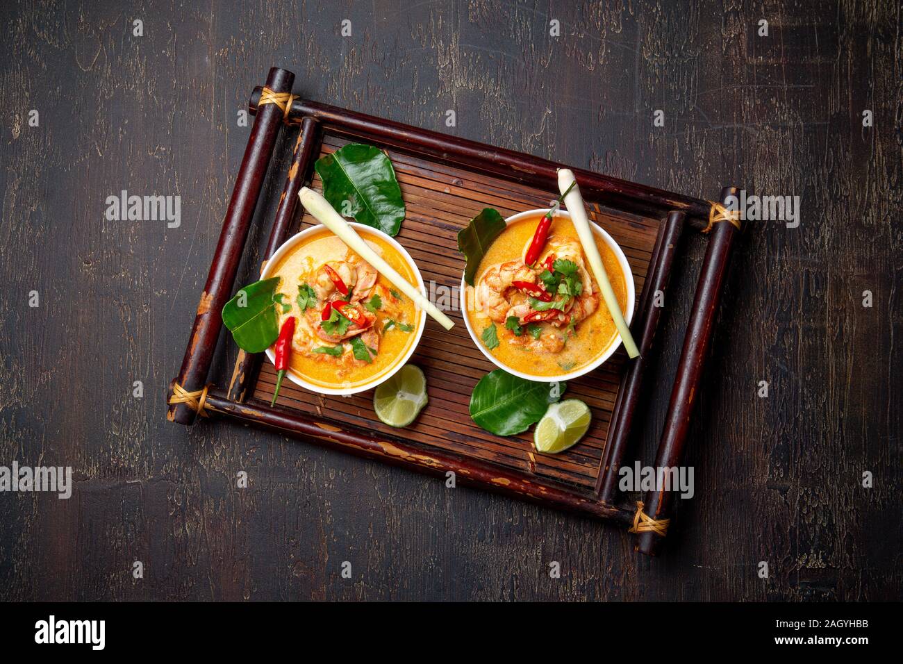 Garnelen Tom Yam Kung in grauen Schale mit thailändischen Gewürzen auf authentisch Fach oben, Holz- Hintergrund. Stockfoto