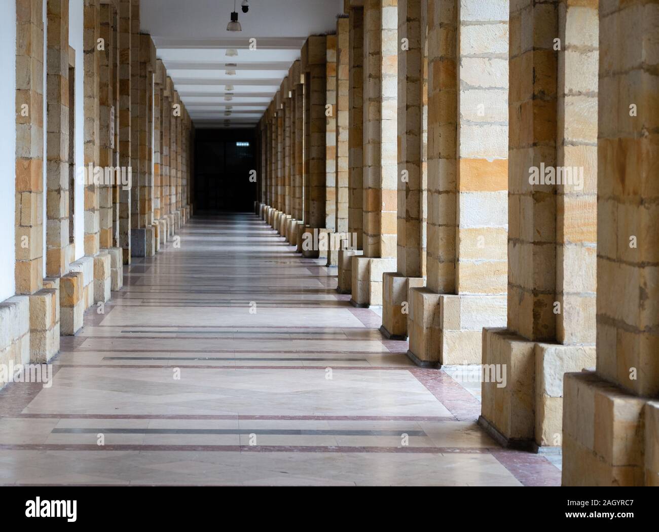 Langer Pass durch viele Säulen, Wirkung der Unendlichkeit. Architektonische Details der Gebäude. Stockfoto