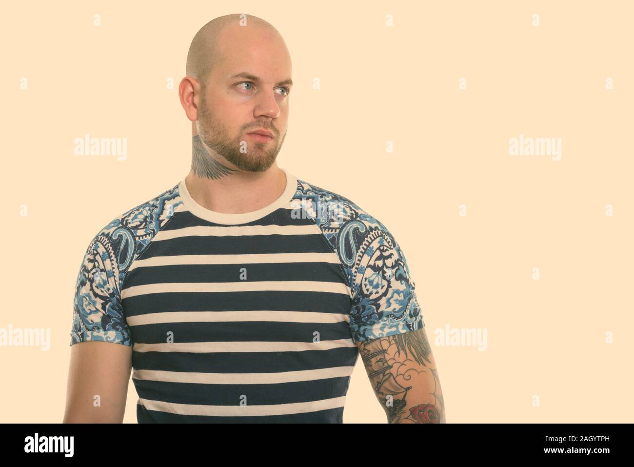 Studio shot der jungen Kahl muskulösen Mann denken, während in der Ferne suchen Stockfoto