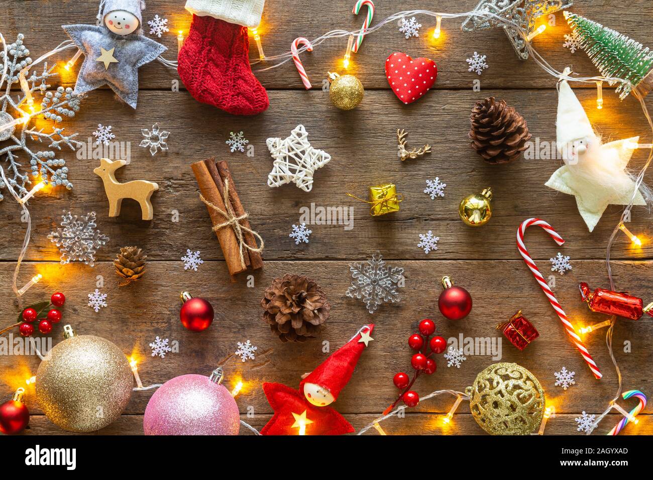 Urlaub Weihnachten Karte Hintergrund mit festlichen Dekoration Kugel, Sterne, Schneeflocken, Geschenkbox, Tannenzapfen auf einem Holz Hintergrund von Flach, Ansicht von oben. Stockfoto