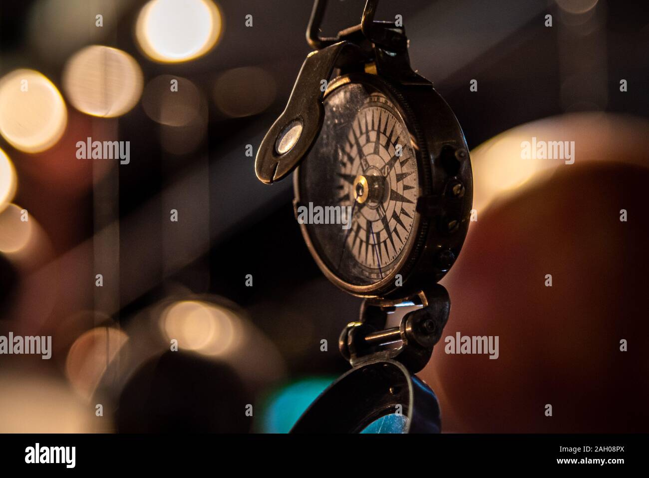 Schönes Bokeh eines Kompass hängen mit Lichtern und Überlegungen in den Hintergrund. Konzept verloren zu gehen, Freiheit und Streben nach Glück. Stockfoto