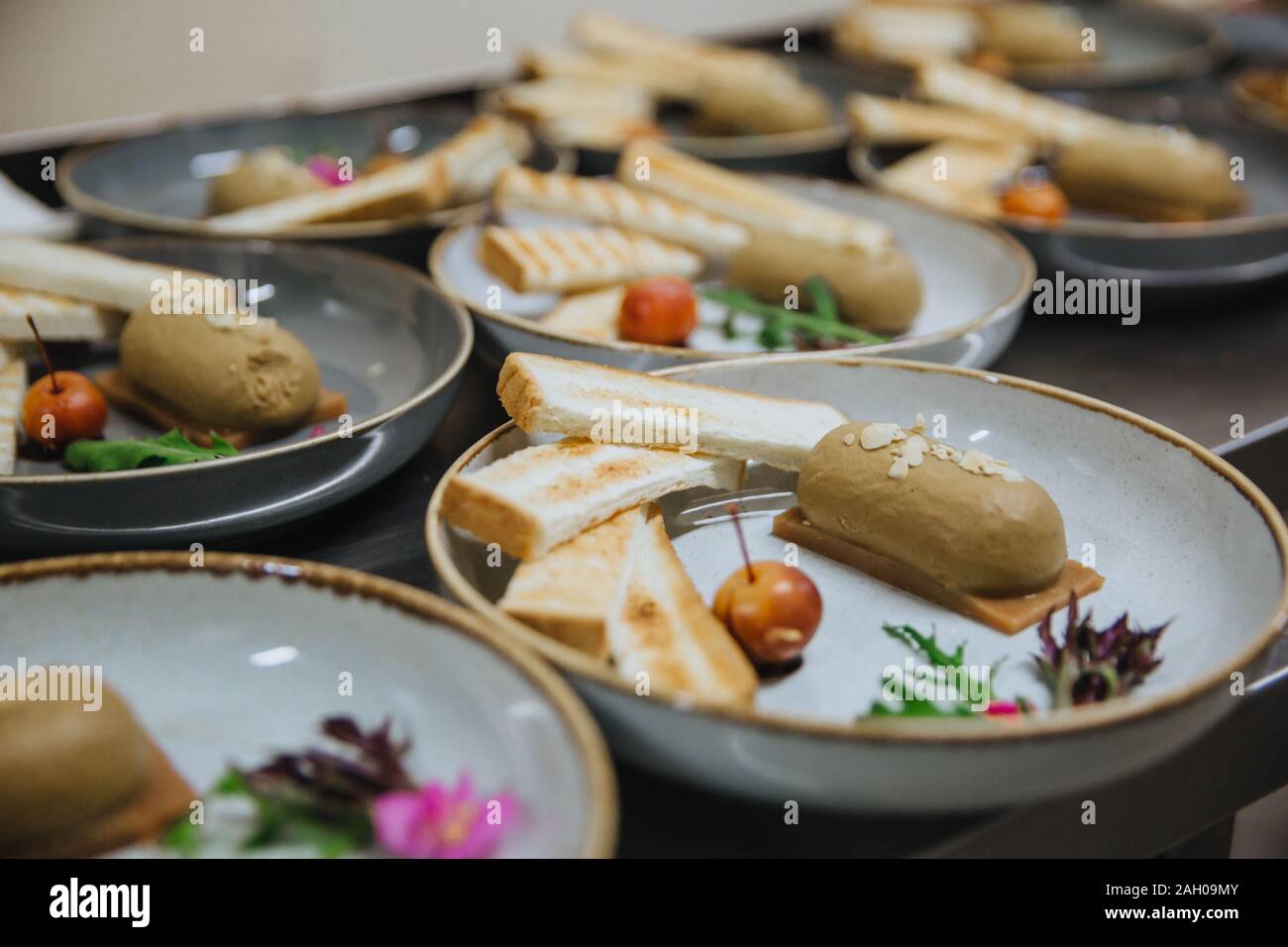 Frische, hausgemachte Pastete mit Scheiben Brot serviert. Das Essen wird auf eine weiße, runde Platte, bereit, bedient zu werden. Stockfoto