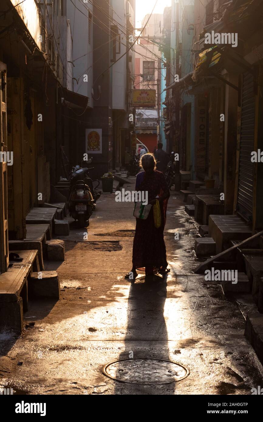 Ältere Frau im Sari, die Schaufel beim Gehen in Alley, Trichy, Tamil Nadu, Indien Stockfoto