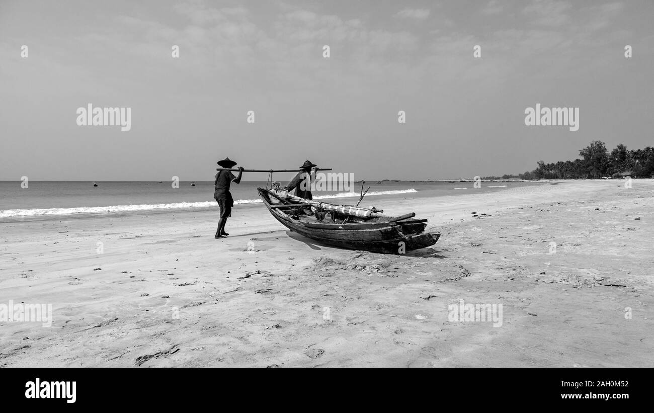 Zwei lokale Fischer an Land Anreise aus dem warmen Wasser der Bucht von Bengalen. Ngapali Beach, Rakhine, Myanmar Stockfoto