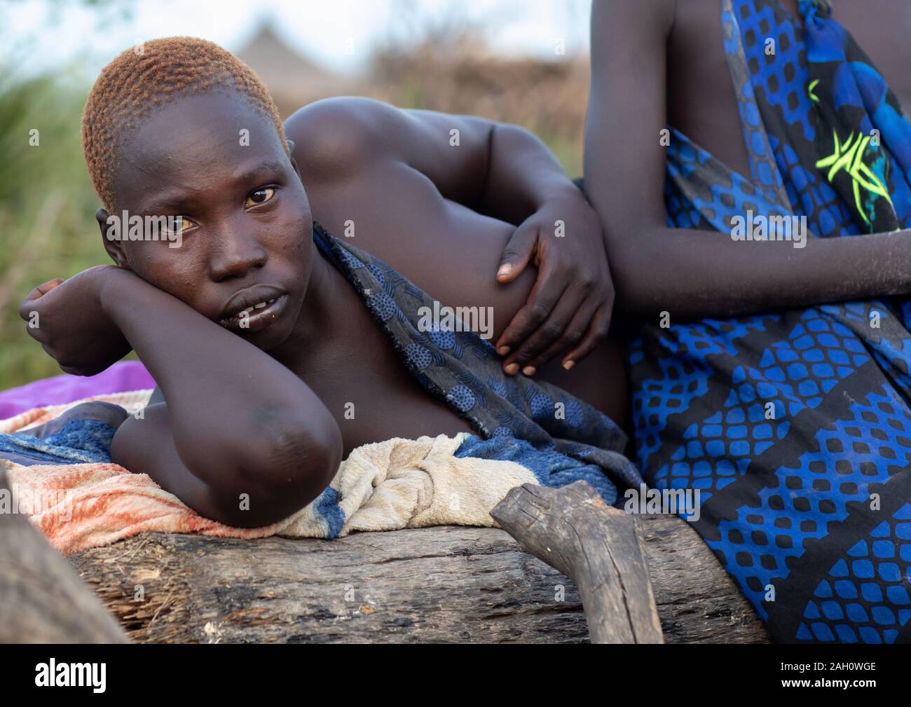 Porträt einer Mundari Stamm Frauen ruht auf einem Bett, Central Equatoria, Terekeka, South Sudan Stockfoto