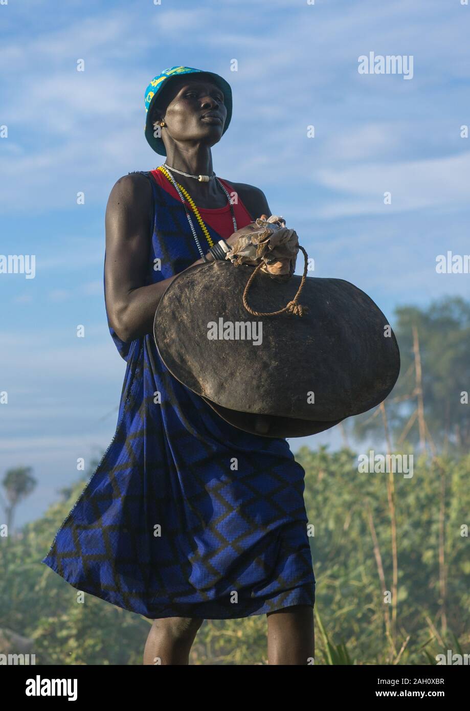 Mundari Stamm Frau, die einen riesigen Glocke beim feiern eine Hochzeit, Central Equatoria, Terekeka, South Sudan Stockfoto