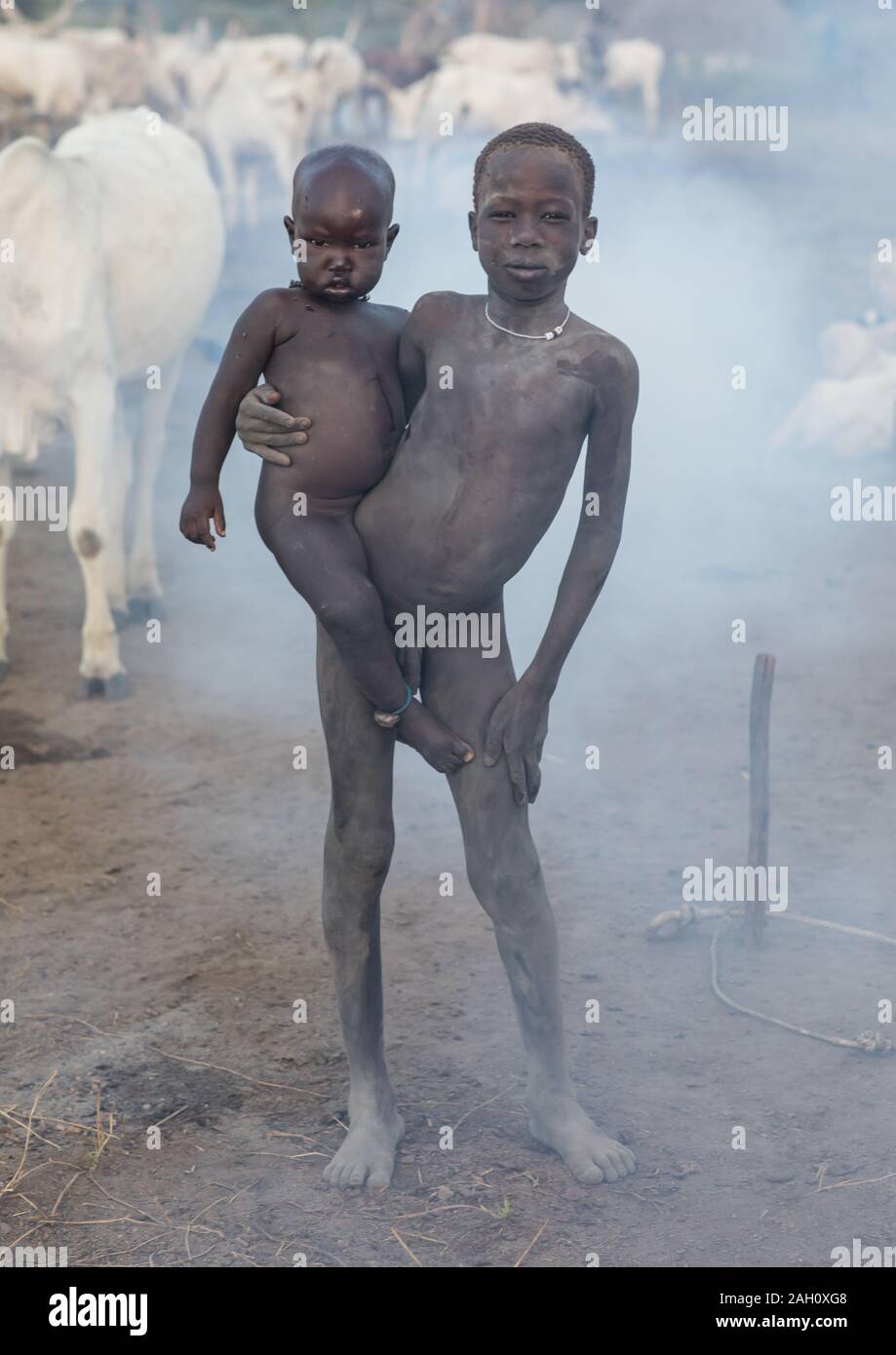 Mundari Stamm Jungen in Asche Pflege des langen Hörner Kühe in einem Camp, Central Equatoria, Terekeka, South Sudan Stockfoto