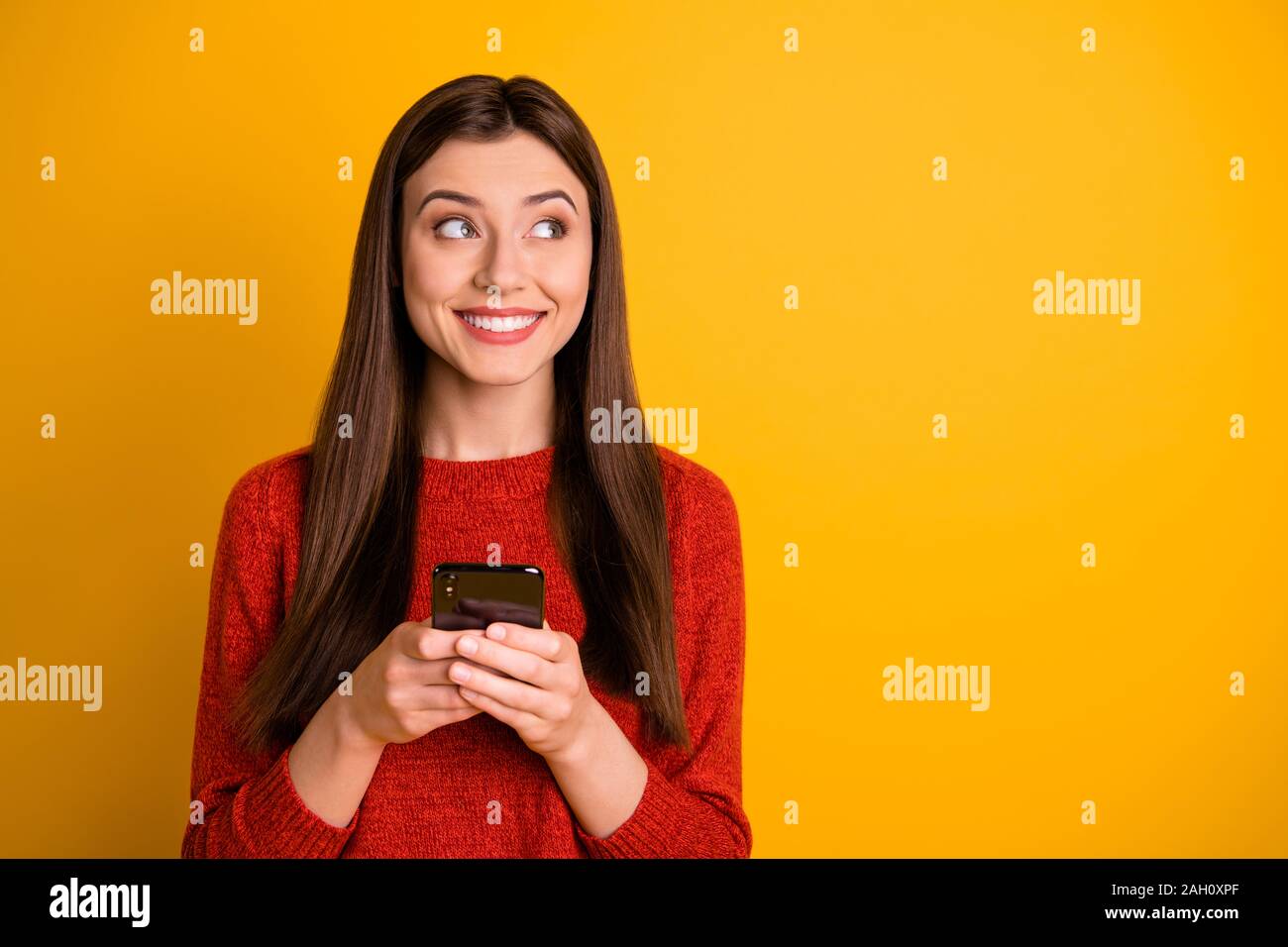 Foto von Beautiful trendy Charmantes hübsches Mädchen holding Telefon Nachdenken über, wie sie gerade starrte in leere Raum über lebendige isoliert Stockfoto