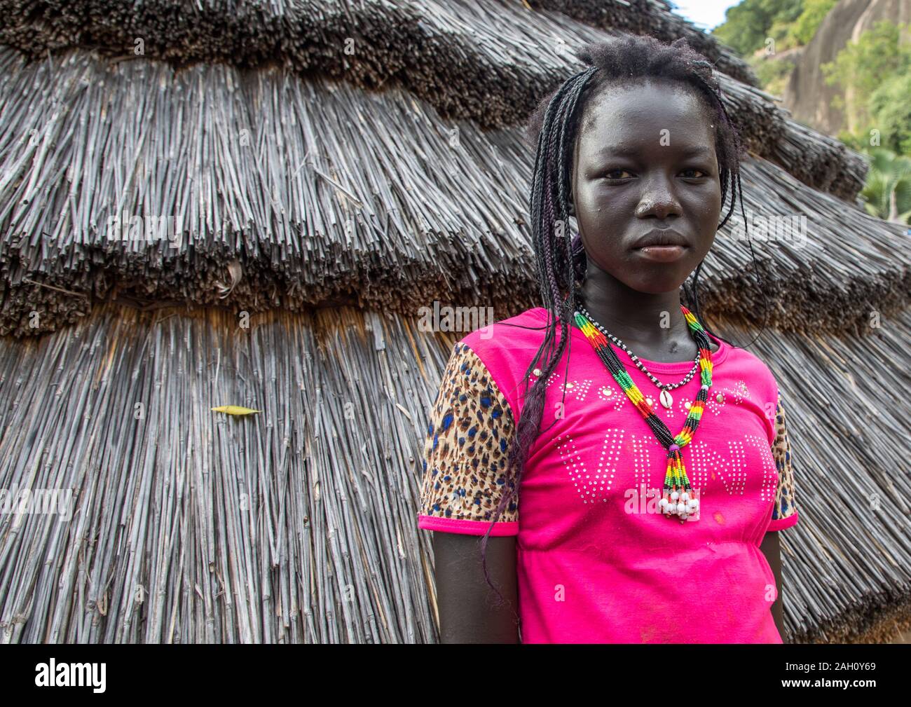 Frau vor einem lotuko Stamm Thatched House, Central Equatoria, Illeu, South Sudan Stockfoto