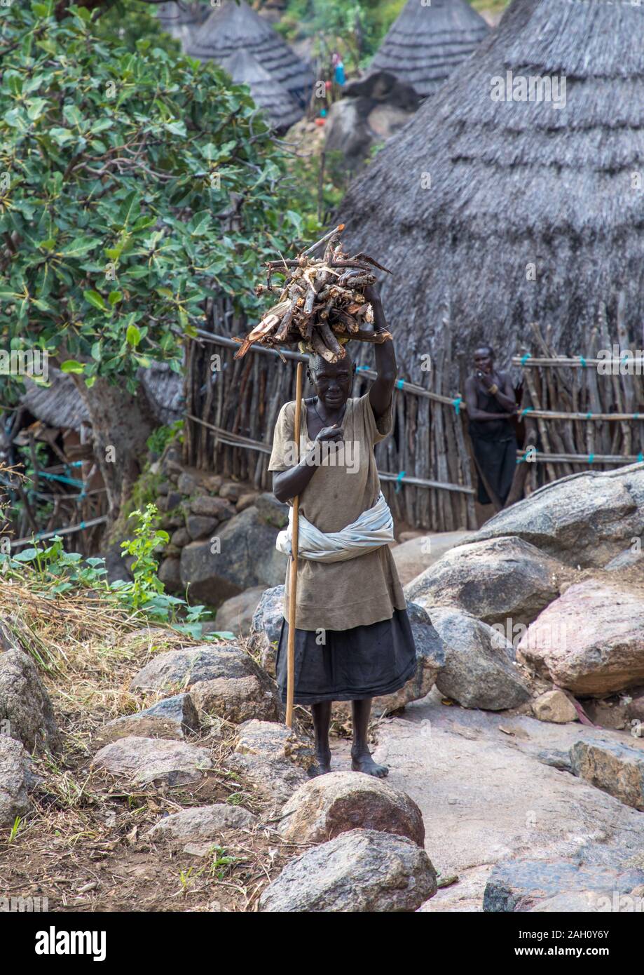 Lotuko Stamm Frau, die Holz auf dem Kopf, Central Equatoria, Illeu, South Sudan Stockfoto