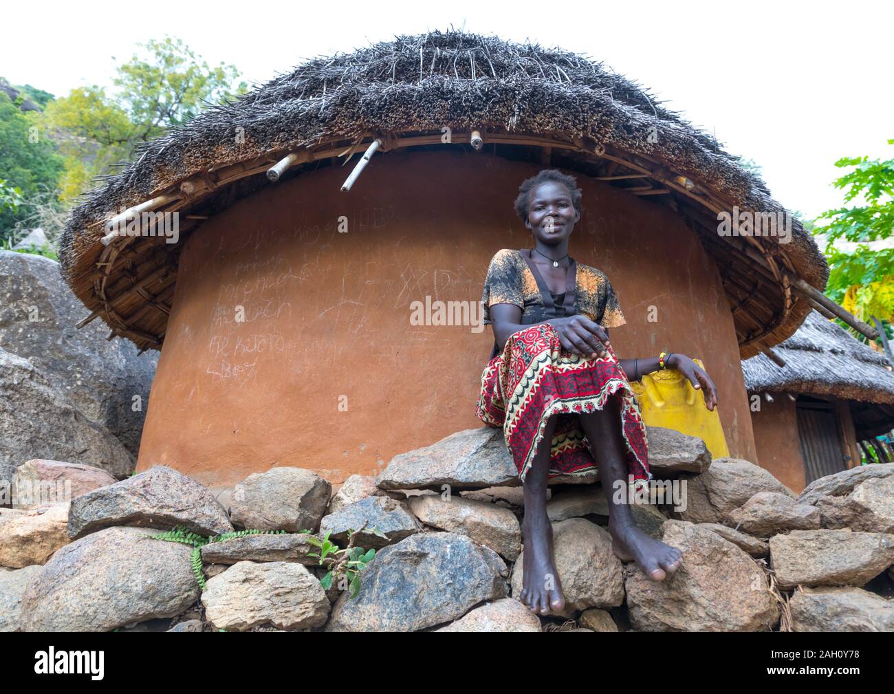 Frau sitzen vor einem lotuko Stamm Thatched House, Central Equatoria, Illeu, South Sudan Stockfoto