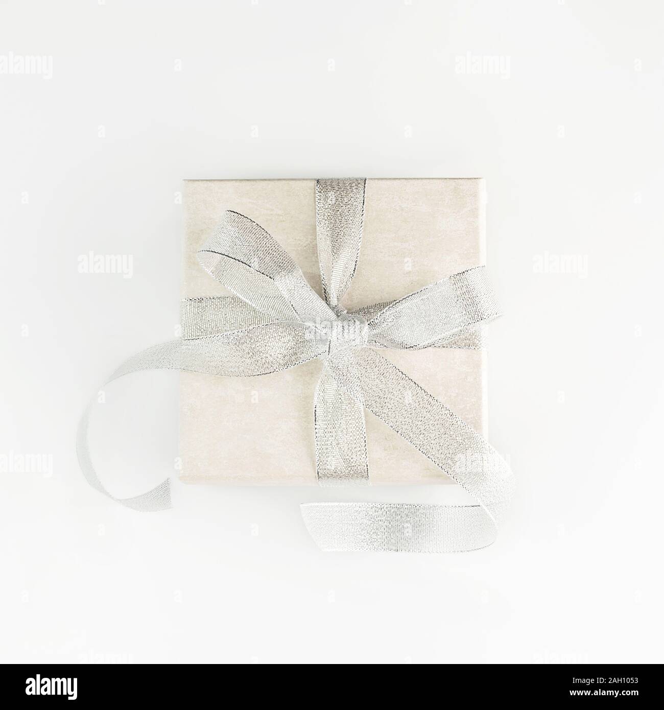 Schönes Geschenk Box mit eleganten Silver Bow auf weißem Hintergrund. Festliche Kulisse für Ihren Urlaub. Flach Stil. Kopieren Sie Platz. Stockfoto