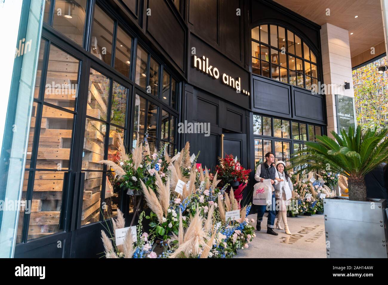 Ein chinesisches Paar Spaziergänge aus dem Flagship Store der japanischen Marke fashion' Niko und...' in Shanghai, China, am 22. Dezember, 2019. Stockfoto