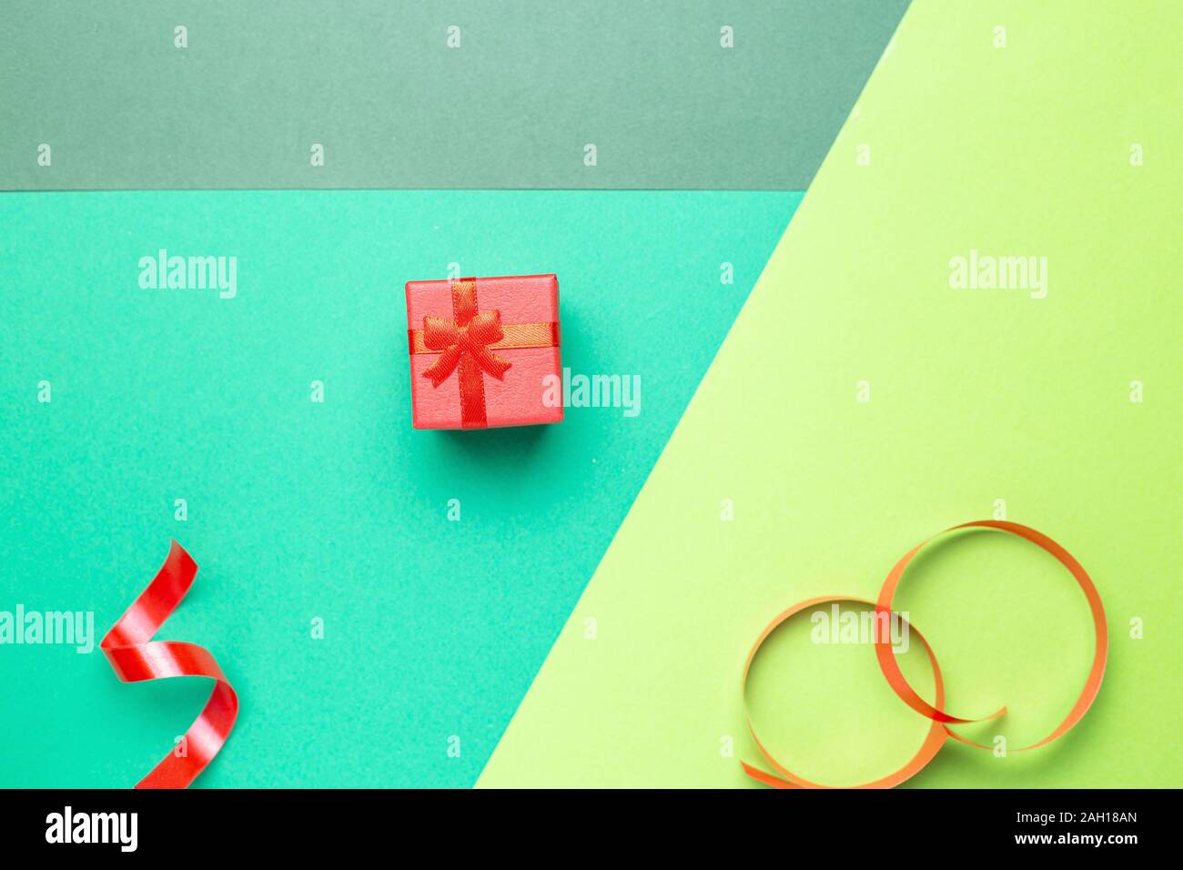 Minimalistische Grußkarte mit roter Geschenkbox über Pastell-hintergrund Präsentation Stockfoto