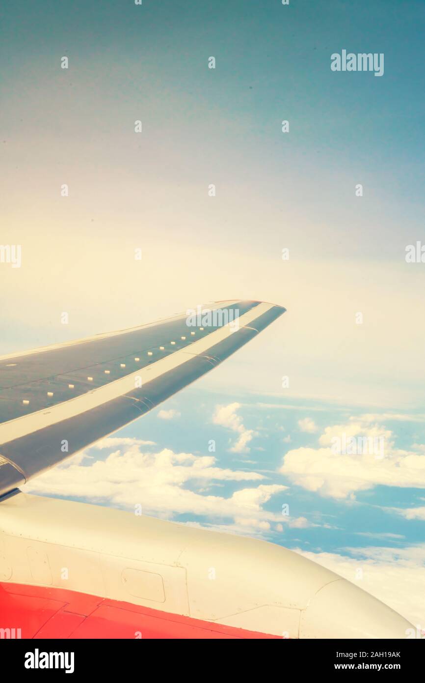 Blick auf Wolken und Himmel. flugzeugflügel aus dem Fenster, getönte Foto. Stockfoto