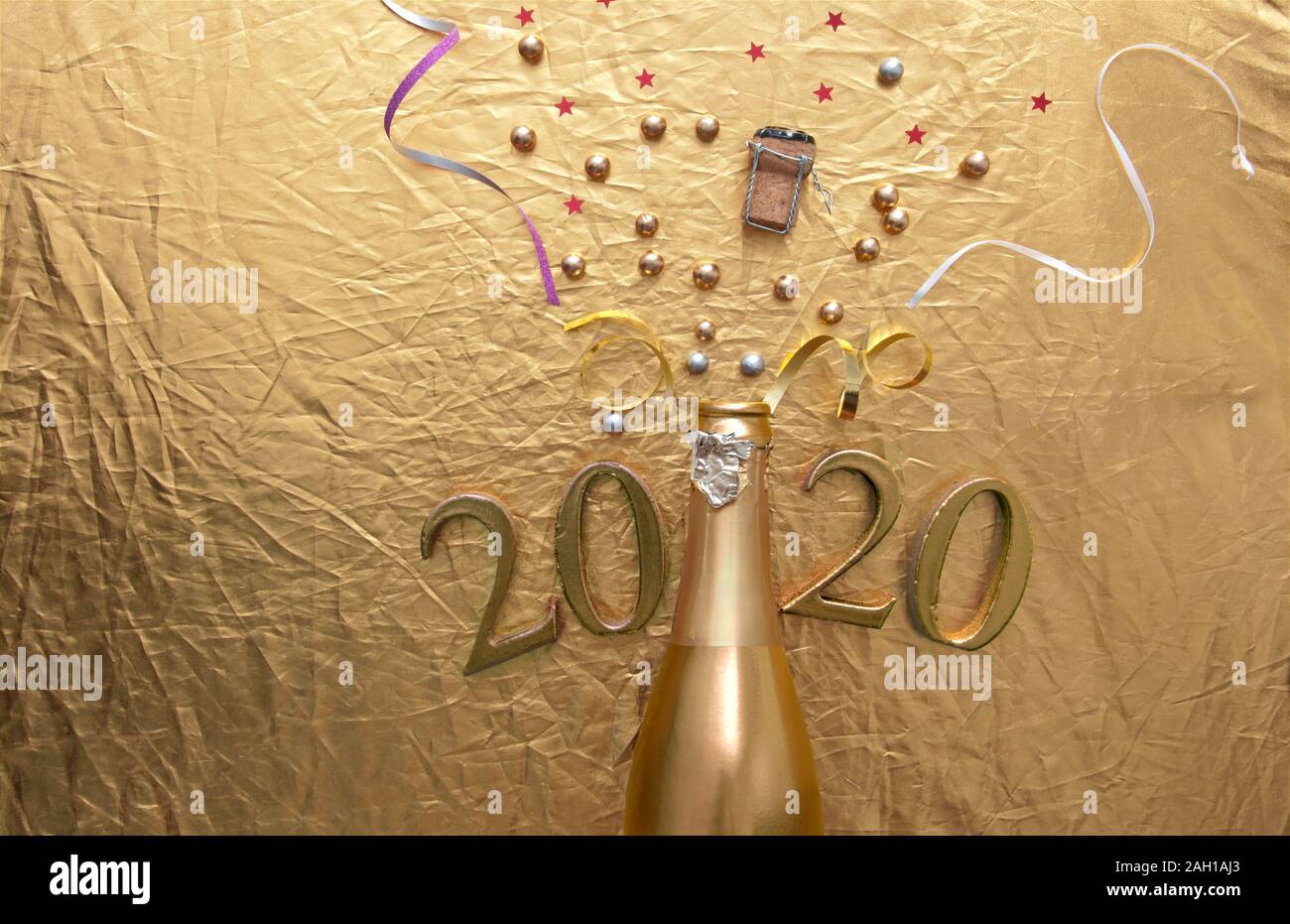 Gold champagne Hintergrund, Konfetti, Flitter, der aus einer Flasche mit 2020 Buchstaben Stockfoto