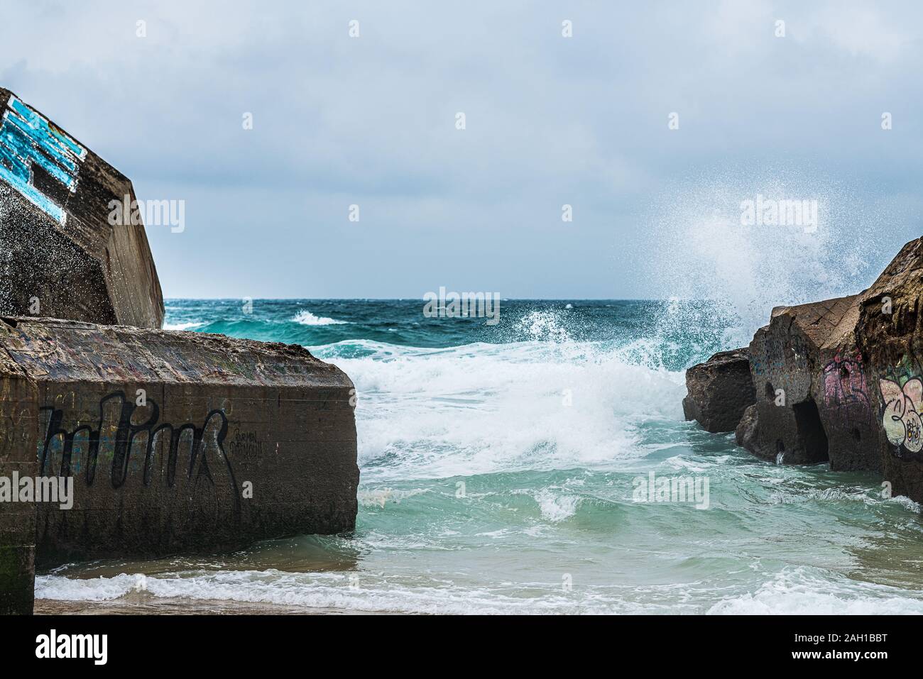 Beton Bunker aus Kriegszeiten Vergangenheit in Shorebreak auf Französisch Strand Stockfoto