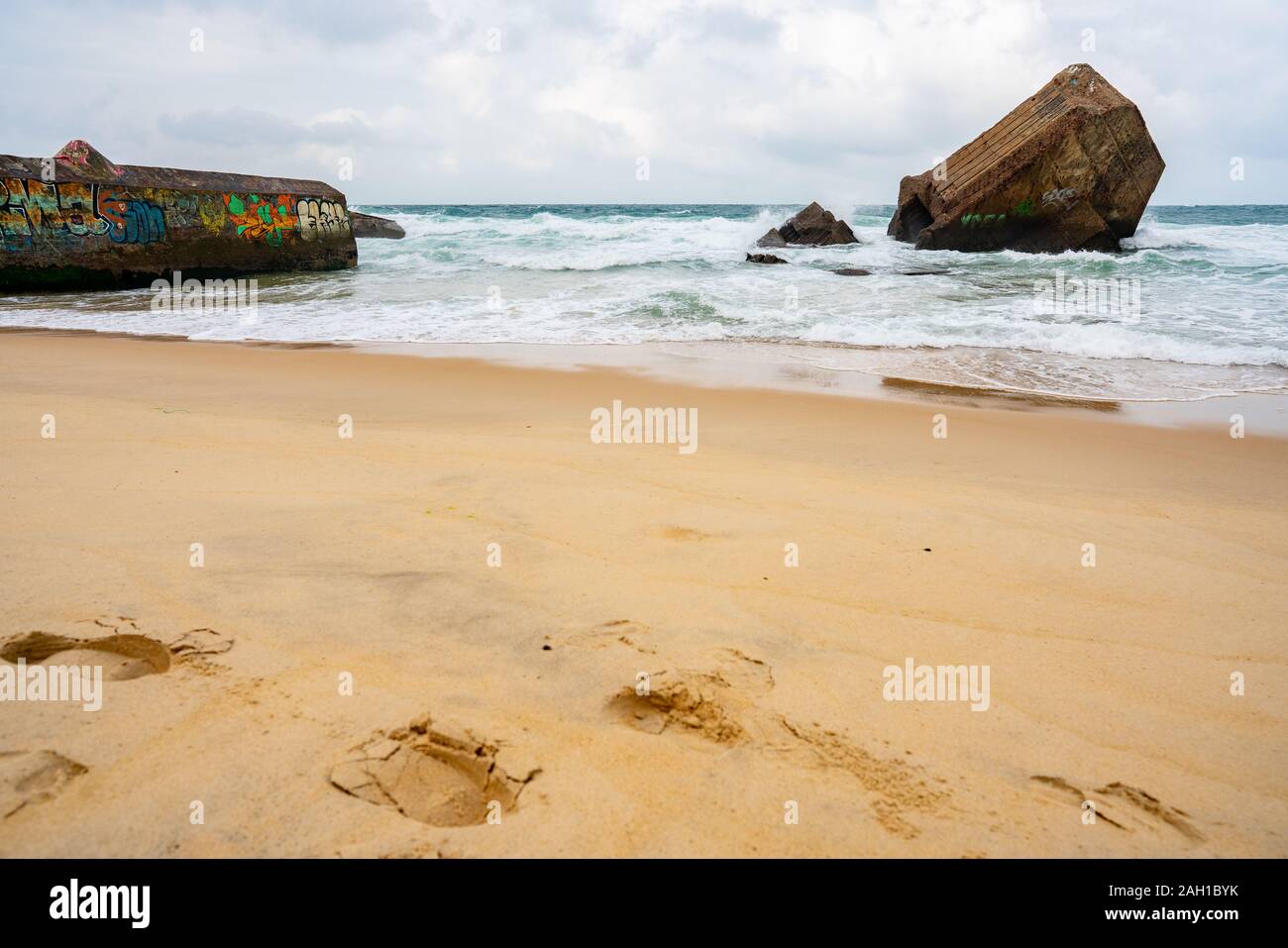 Beton Bunker aus Kriegszeiten Vergangenheit in Shorebreak auf Französisch Strand Stockfoto