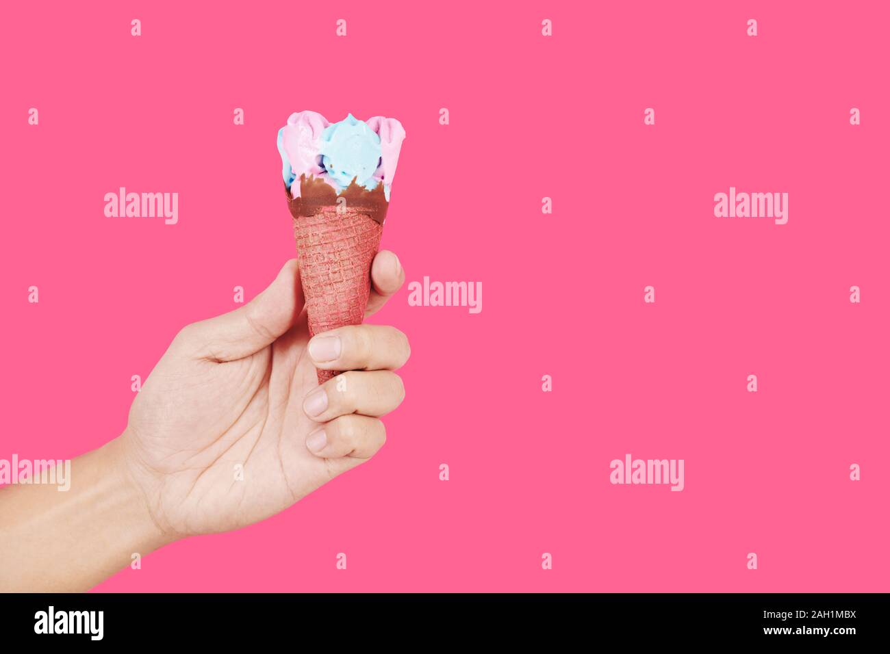 Hand mit leckeren Rosa und Blau Eis in der Waffel Mais Stockfoto