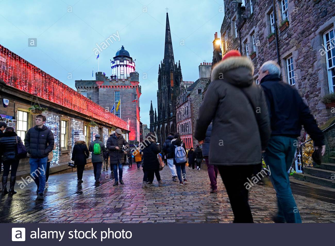 Edinburgh, Schottland, Großbritannien. 23. Dez 2019. Weihnachtsbeleuchtung und voll mit Touristen, die sich in der Royal Mile in der Abenddämmerung Ansätze. Blick auf die Camera Obscura. Quelle: Craig Brown/Alamy leben Nachrichten Stockfoto