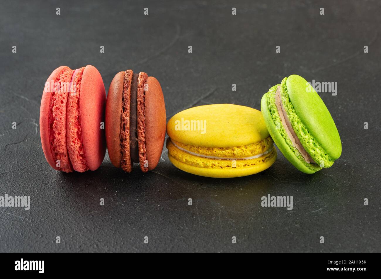 Köstliche vier farbigen Makronen auf einem dunklen Hintergrund Stockfoto