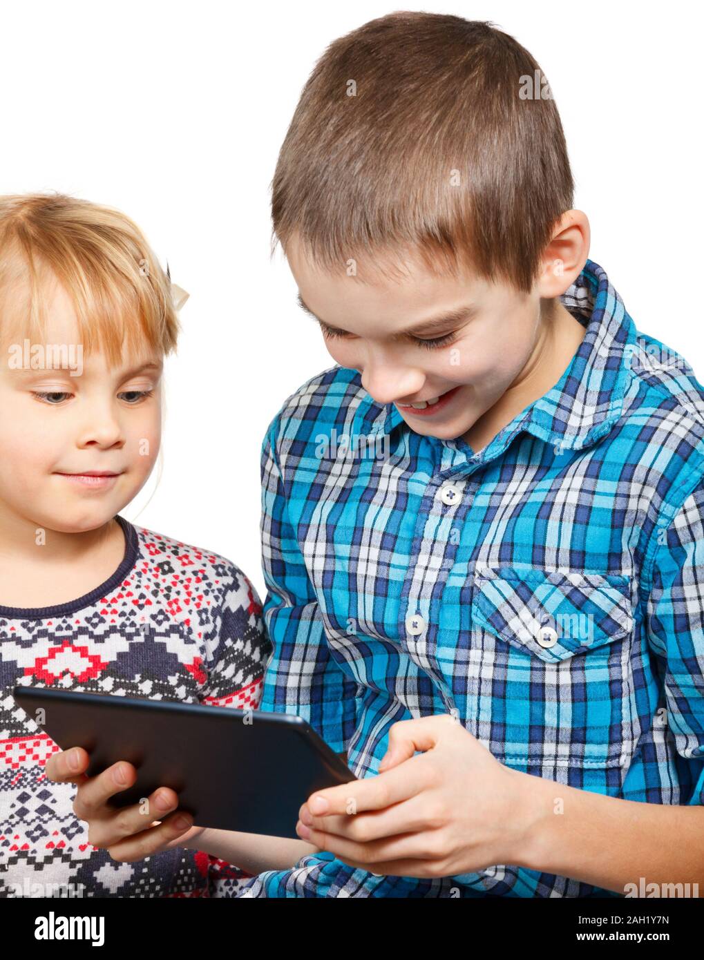 Junge spielt auf einem Touchpad mit kleinen Schwester Stockfoto