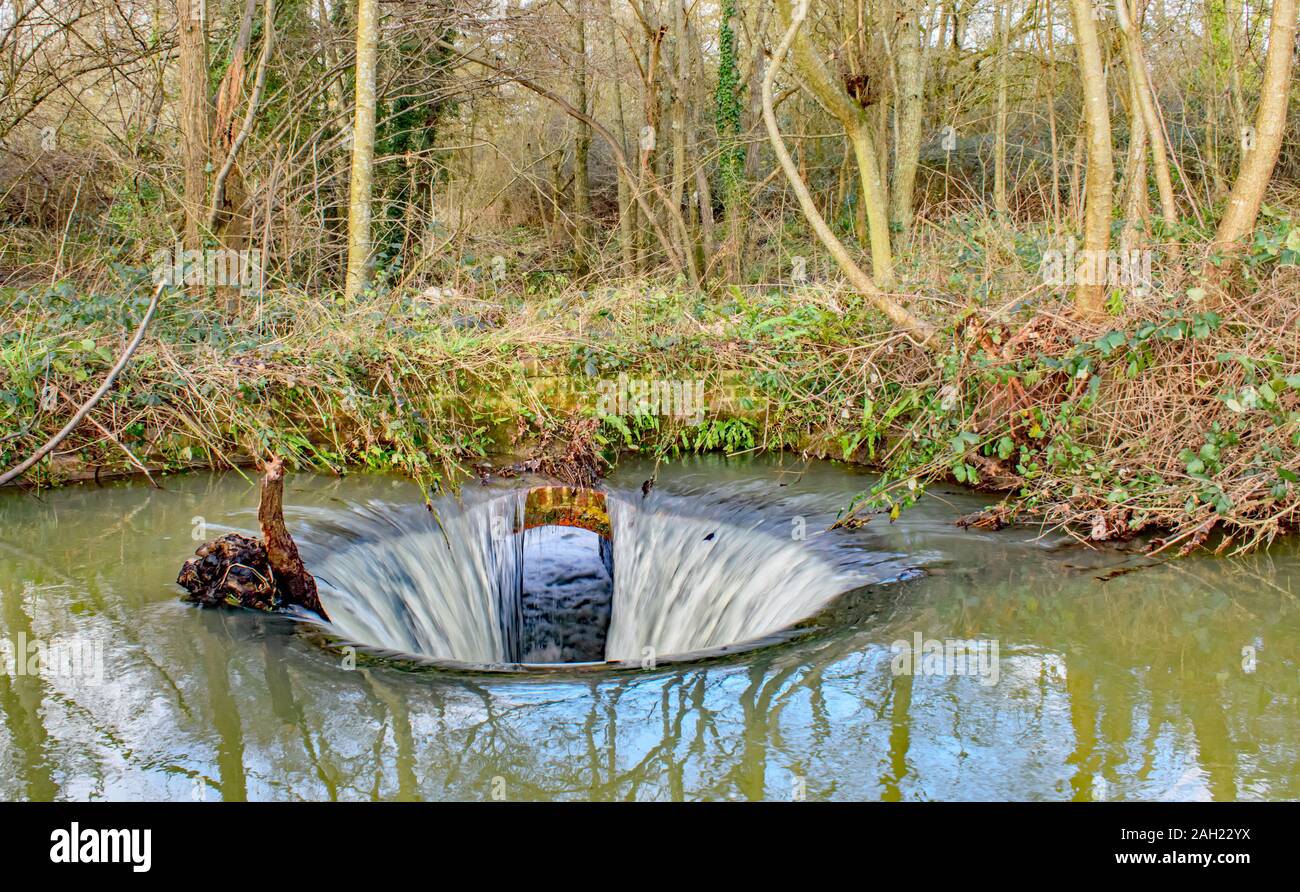 Wasser fällt die versteckten Abfluss in den Waldbach Stockfoto