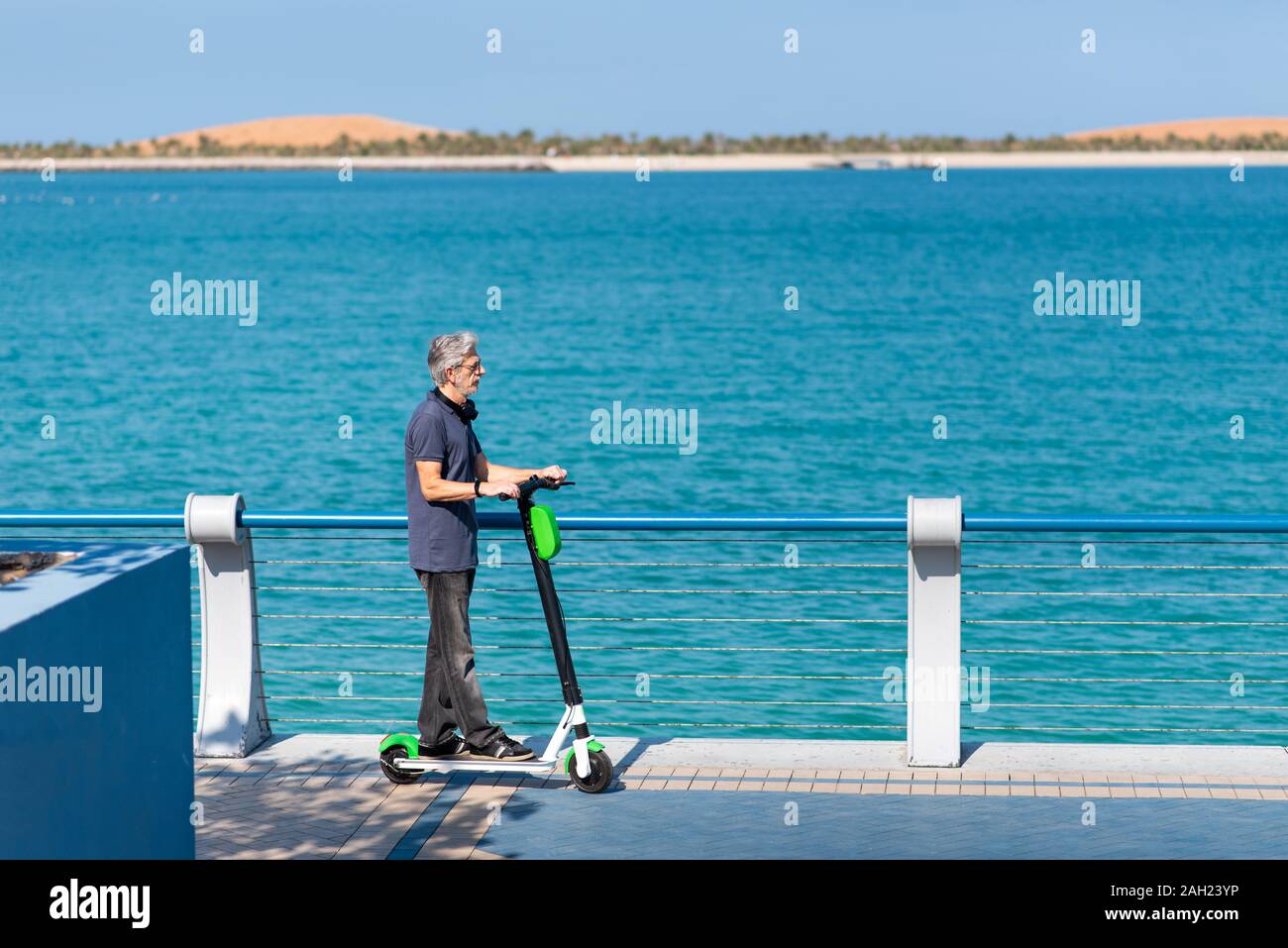 Ältere Menschen mit elektrischer Roller für den Transport durch die Küste Stockfoto