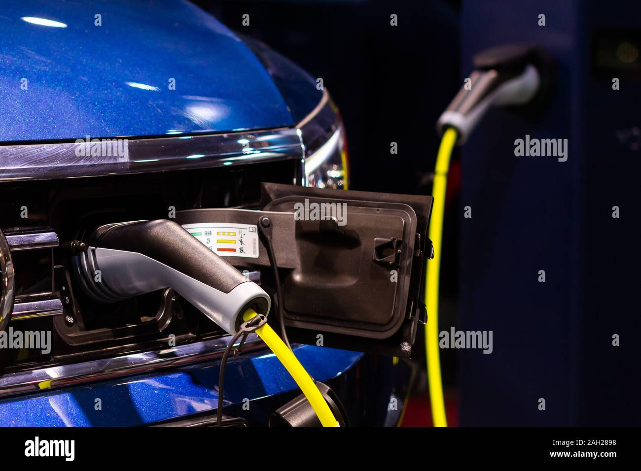 Eine elektrische oder hybride PHEV Auto mit dem Netzkabel Netzteil angeschlossen. Elektroauto Ladestation Stockfoto