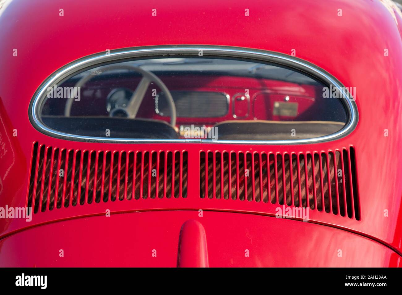 Die Rückseite eines klassischen roten VW Käfer, oder Fehler, die das Lenkrad und Armaturenbrett durch das Fenster. Stockfoto