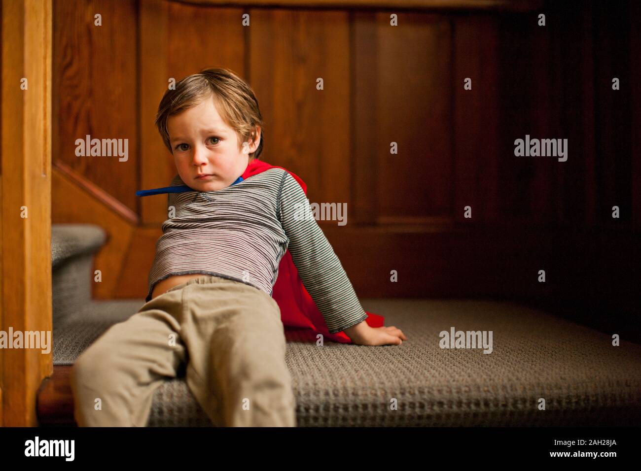 Portrait eines unglücklichen Jungen sitzen auf einer Treppe. Stockfoto