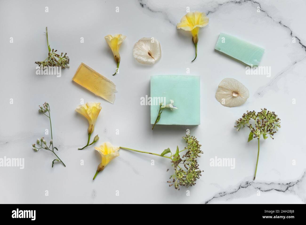 Organic Natural blue Seife für Spa oder Körperpflege mit wilden gelbe Blume auf weißem Marmor Stein Hintergrund Stockfoto