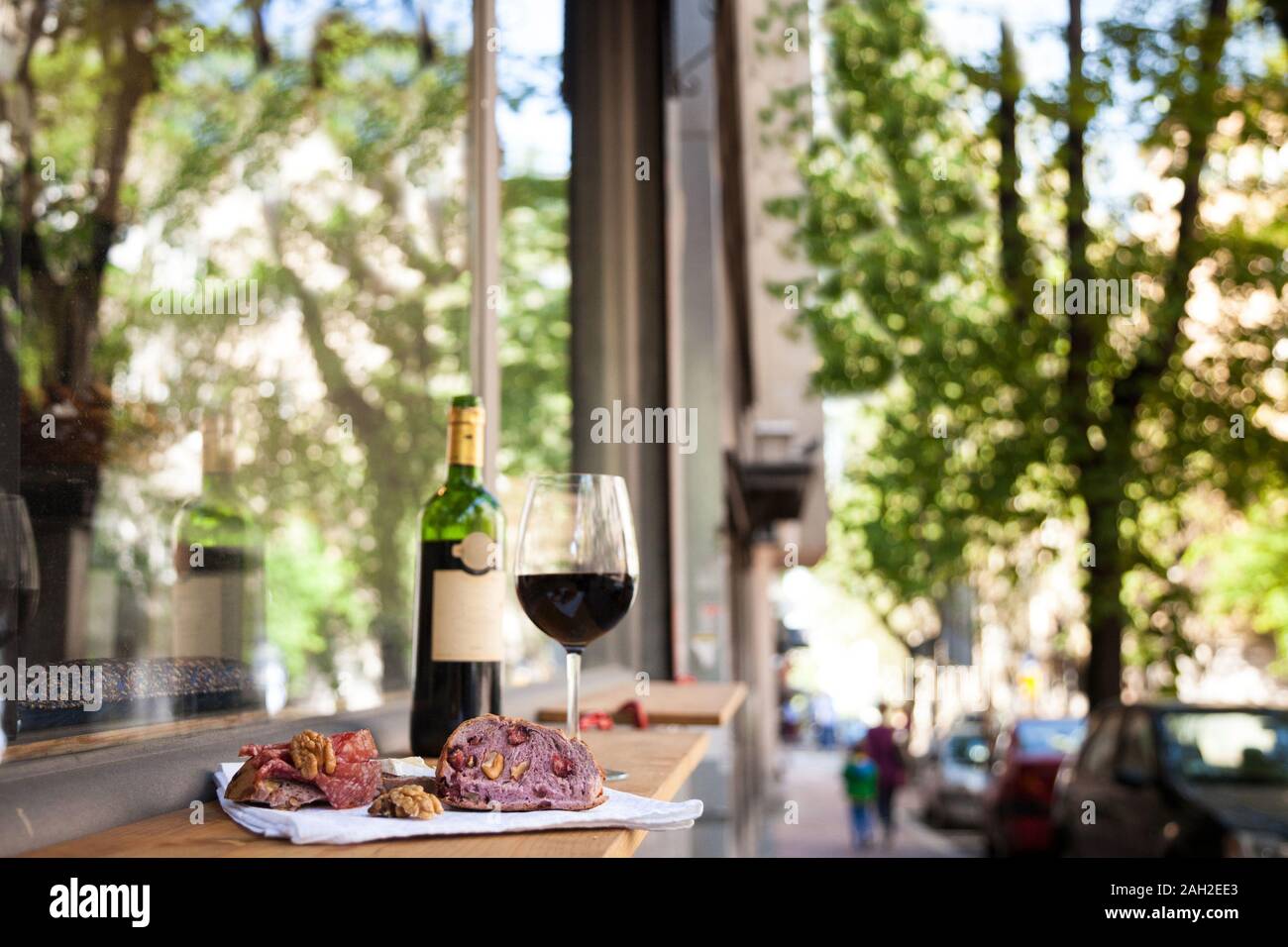 Scheiben Baguette, Brie Käse und saucisson (a Wurst aus Frankreich) für Vorspeisen mit Glas und Flasche französischen Rotwein, verschwommen in t Stockfoto