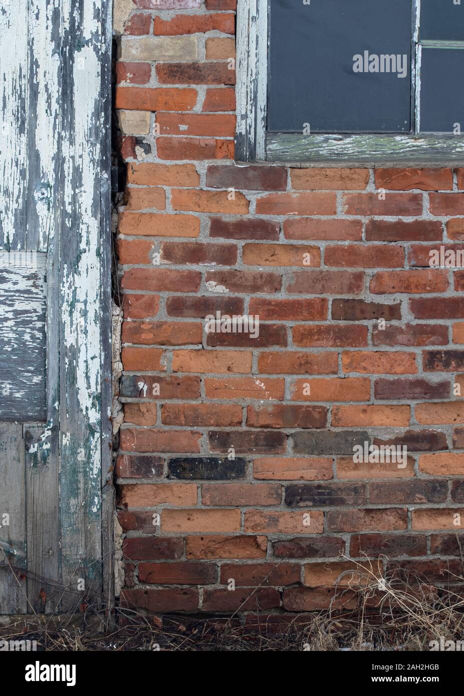 Alte hölzerne Tür und Fenster und Red brick wall in einem vernachlässigten Gebäude. Stockfoto