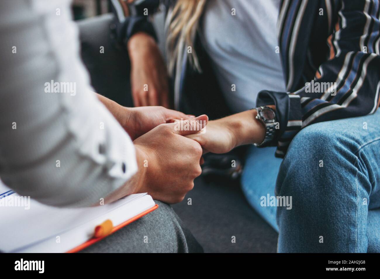 Frau Unterstützung und Hilfe. Frauen halten einander die Hände sitzen in der modernen Loft Büro Stockfoto