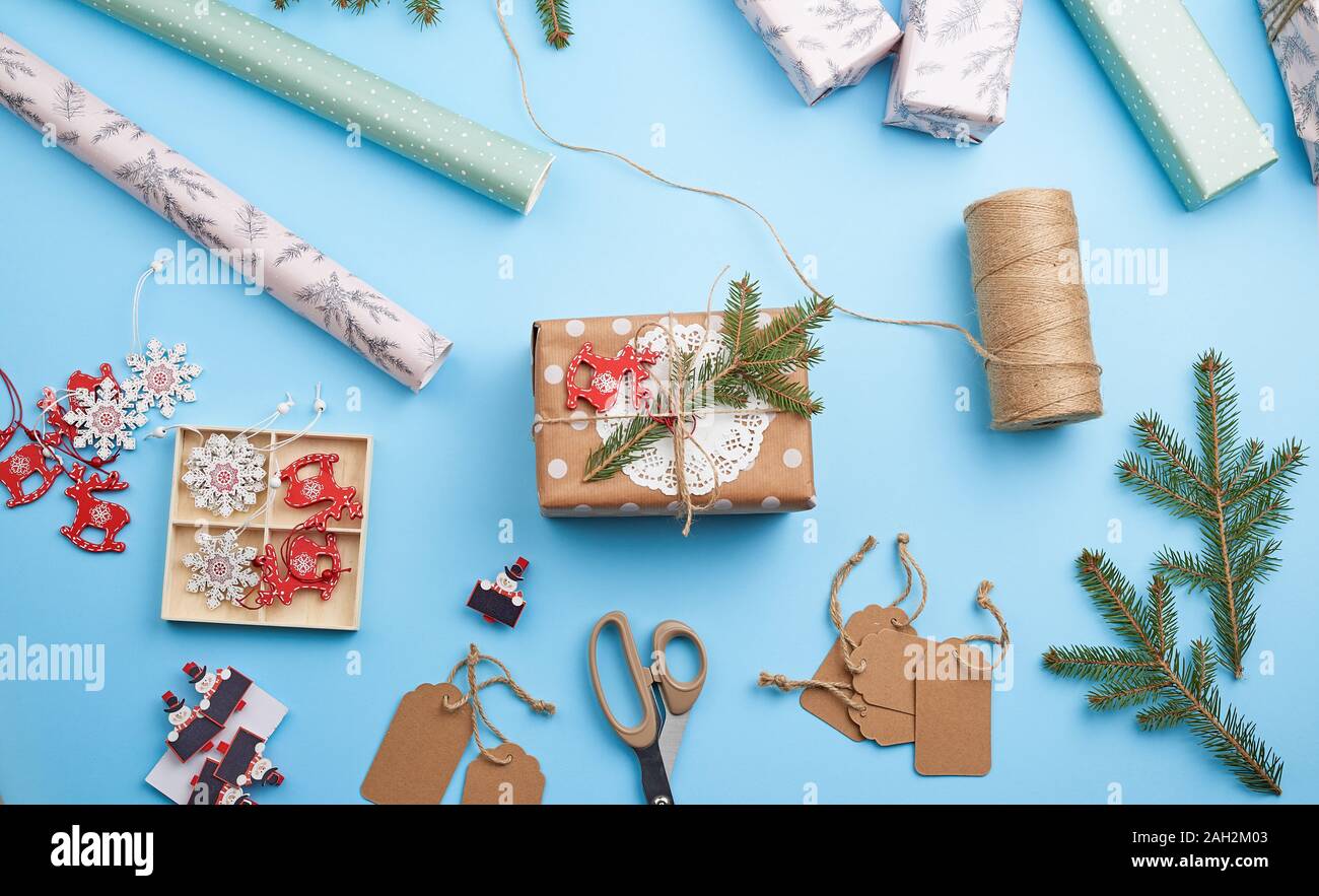 Rolle von rosa Geschenkpapier, Dekor, Zweige Fichte, Weihnachten Spielzeug und Kartons mit Geschenken auf blauem Hintergrund, Ansicht von oben. Weihnachten Konzept Stockfoto