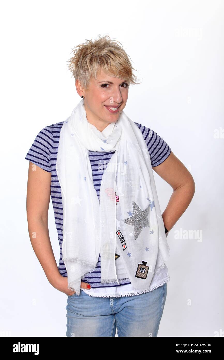 Lächelnde blonde Frau mit einem Schal vor weißem Hintergrund posiert, Portrait. Stockfoto