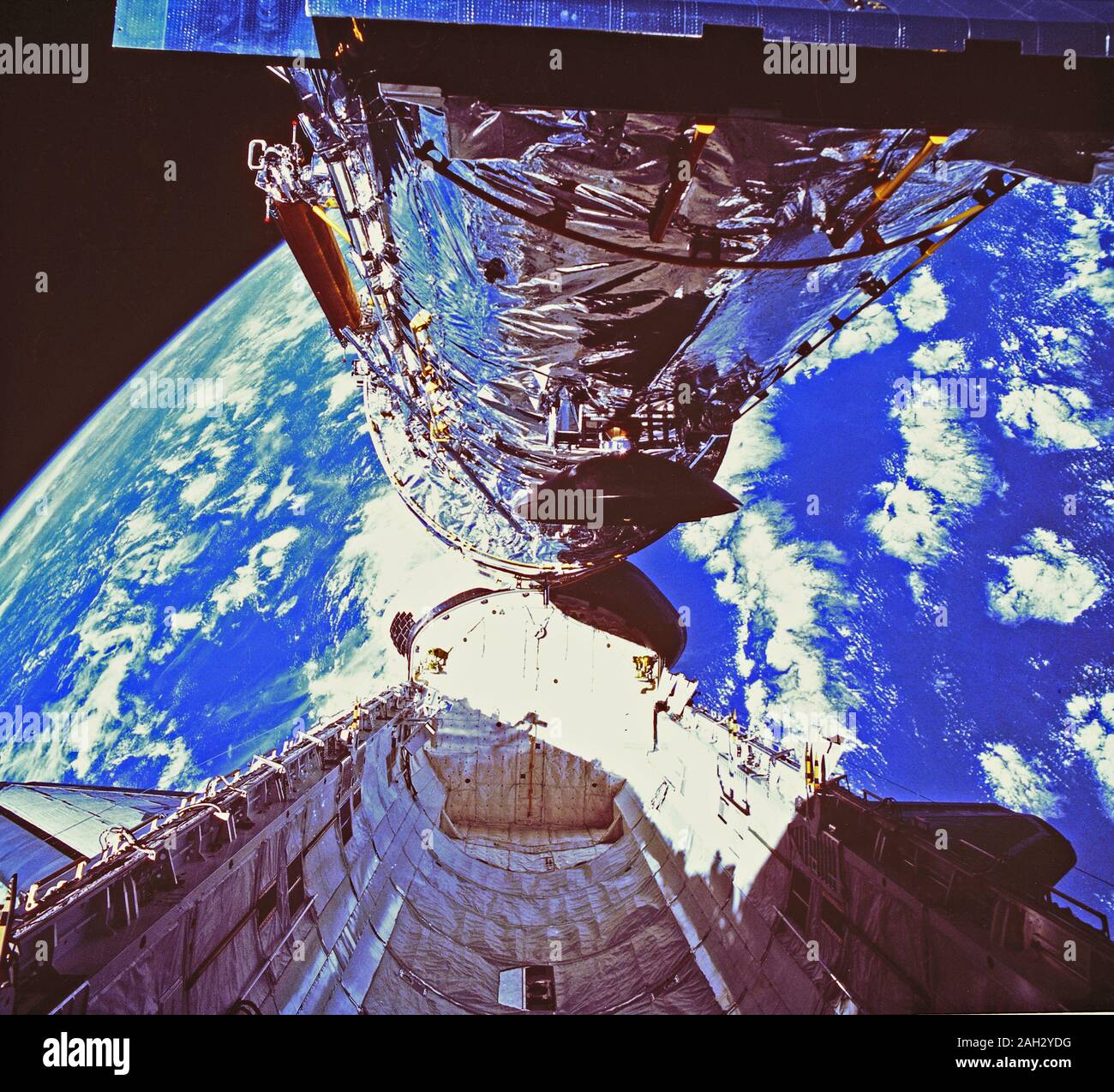 Auf diesem Foto, das Hubble Space Telescope (HST) Löscht das Cargo Bay während der Bereitstellung am 25. April 1990. Das Foto wurde von den IMAX-Cargo Bay Kamera (ICBC) in einem Container auf der Backbordseite des Space Shuttle Orbiter Discovery STS-31 Mission montiert. Stockfoto