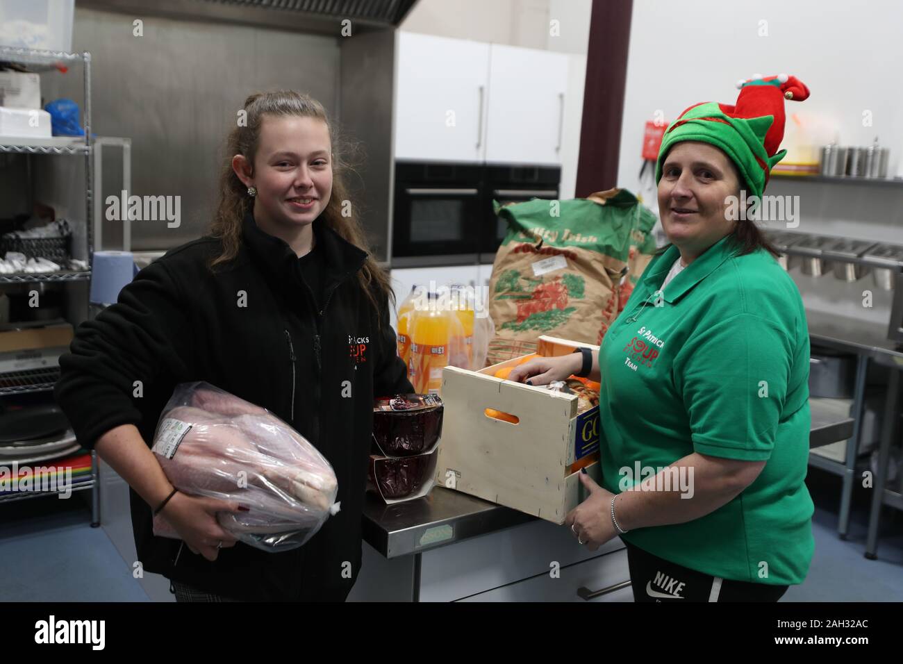 Freiwillige Susan Laverty (links) und Mandy Bickerstaffe in der Küche an der St Patrick's Kirche Suppenküche, Belfast, in der Vorbereitung für ihre Weihnachtsfeier. Stockfoto