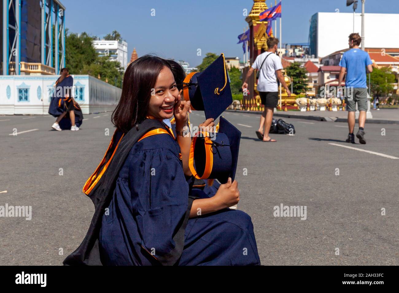 Eine Gruppe der weiblichen Absolventen der Mengly J Quach Bildung sitzt vor dem Königlichen Palast ihre Diplome in Phnom Penh, Kambodscha. Stockfoto