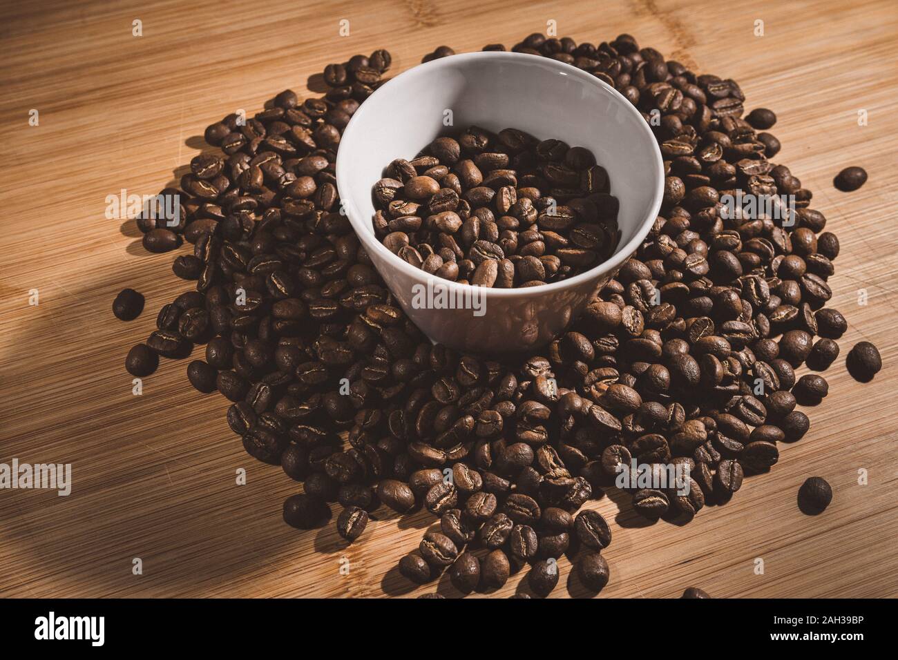 Tasse Kaffee Bohnen gebraten auf einem hölzernen Tisch mit frischen Bohnen mit großartiges Aroma Stockfoto